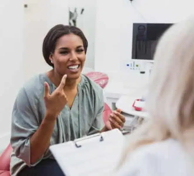 brooklyn-dentist-first-visit-consultation Patient smiling while discussing treatment goals during a first dental visit
